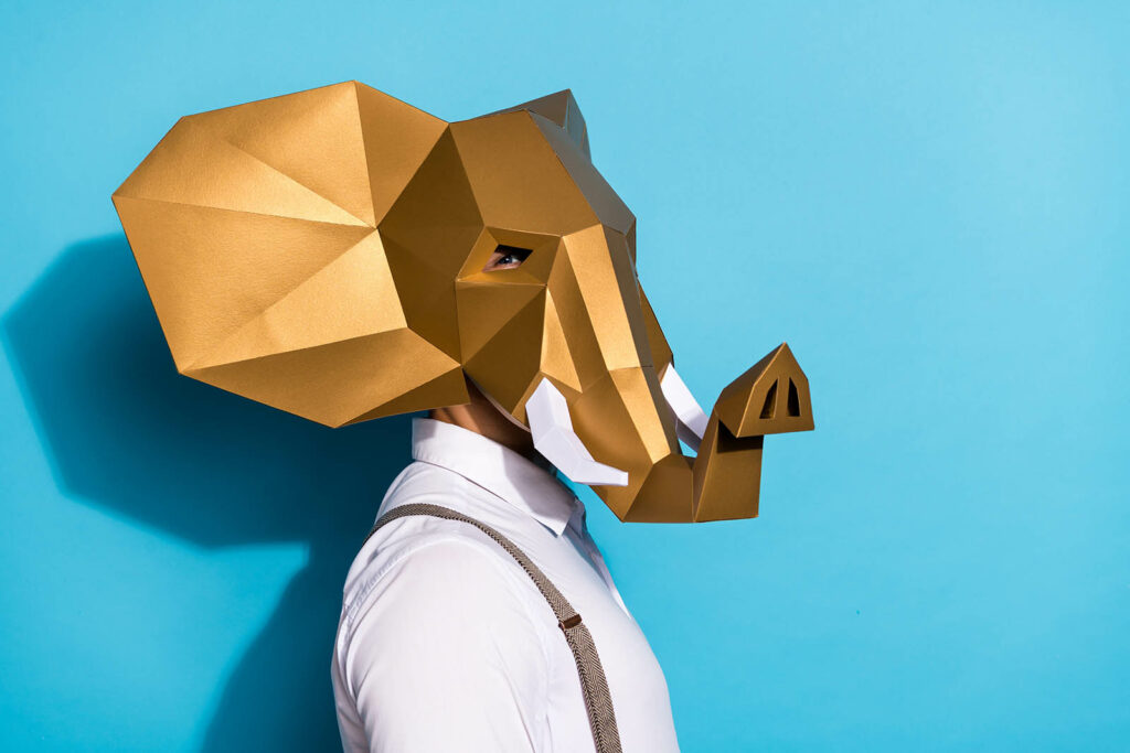 Photo of excited serious man wear gold elephant mask looking empty space isolated blue color background